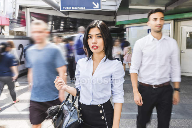 Thailand, Bangkok, portrait of businesswoman amidst moving people in the city — Stock Photo