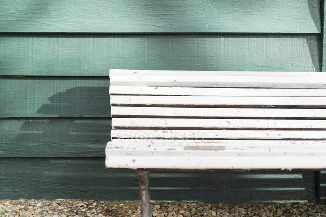Пустая белая деревянная скамейка — стоковое фото