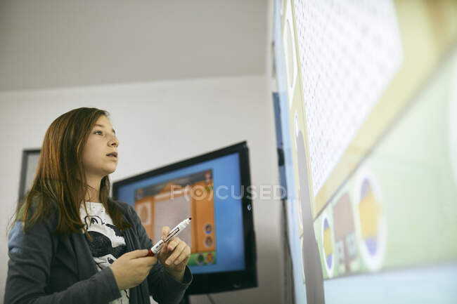Estudante em sala de aula olhando para quadro interativo — Fotografia de Stock
