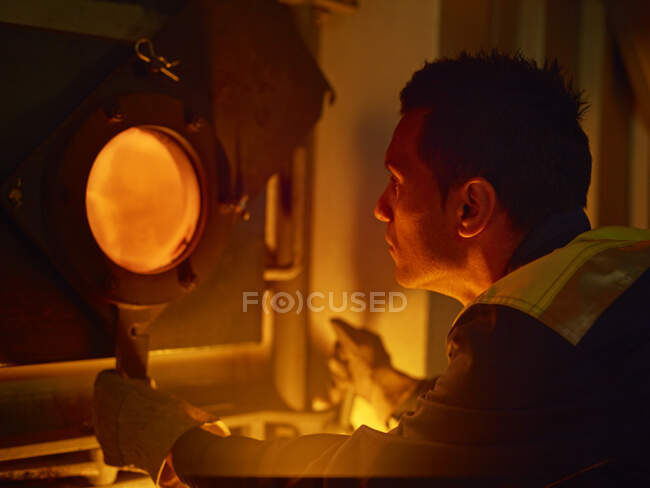 Worker controlling of combustion in furnace — Stock Photo