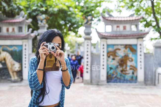 Vietnam, Hanoi, young woman taking a picture with old-fashioned camera — Stock Photo