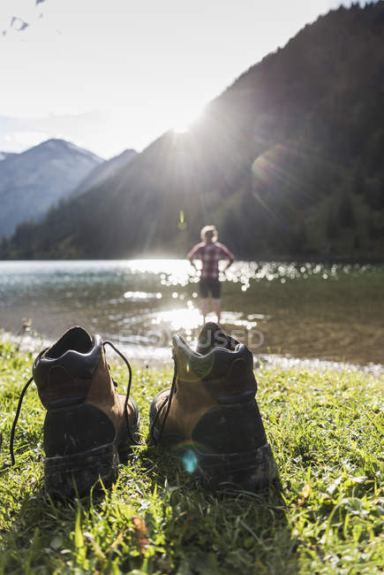 Австрия, Тироль, туристическая обувь и женщина освежает в горном озере — стоковое фото