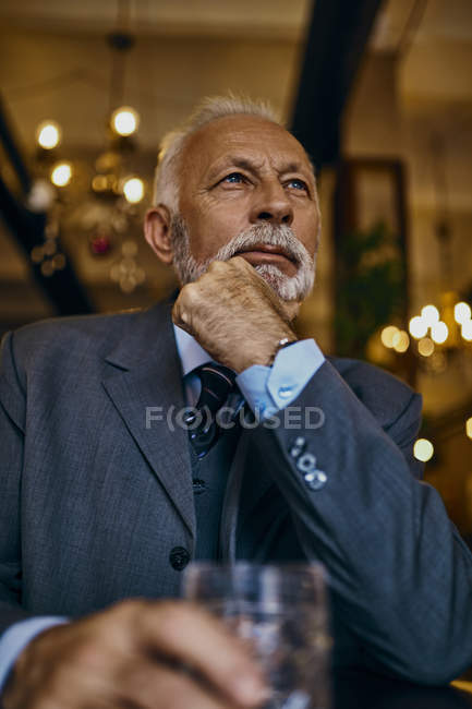 Ritratto di uomo anziano elegante in un bar con bicchiere — Foto stock