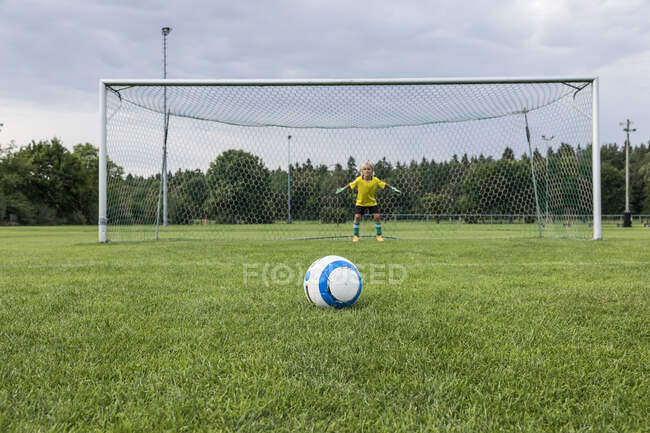 Молодой футбольный вратарь с мячом на футбольном поле — стоковое фото
