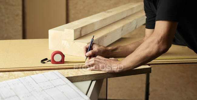 Trabajador marcando madera con lápiz, cinta métrica - foto de stock