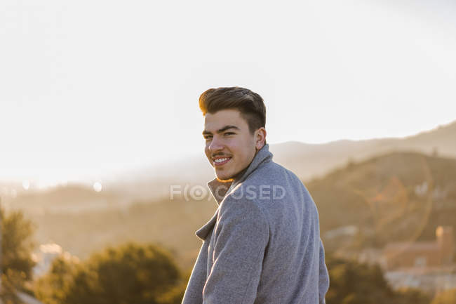 Portrait de jeune homme souriant au coucher du soleil — Photo de stock