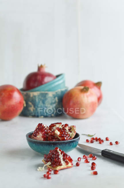 Sliced pomegranate and knife on table — Stock Photo