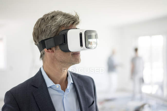Uomo in giacca e cravatta con occhiali VR in costruzione — Foto stock