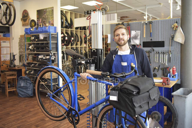 Mecánico de bicicletas en su taller de reparación, retrato - foto de stock