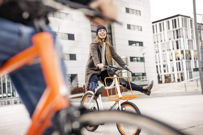 Безтурботна жінка з людиною їзда на велосипеді в місті — стокове фото