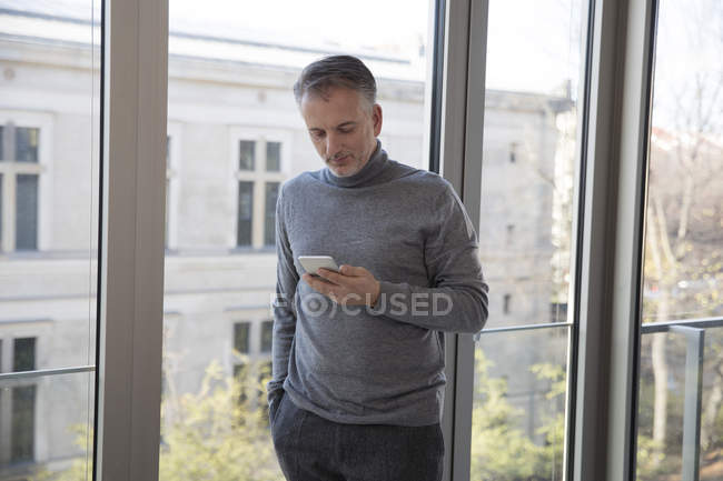 Businessman using smartphone at home — Stock Photo
