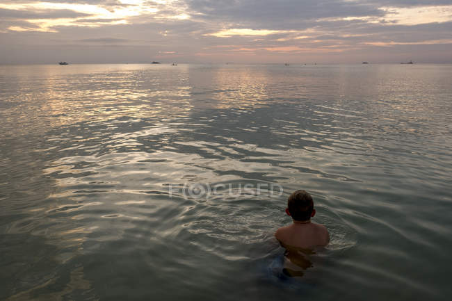 Таиланд, мальчик купается на закате — стоковое фото
