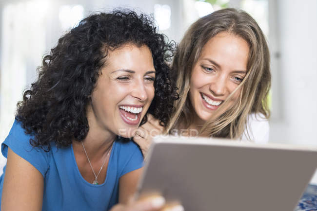 Дві щасливі жінки дивляться на планшеті — стокове фото