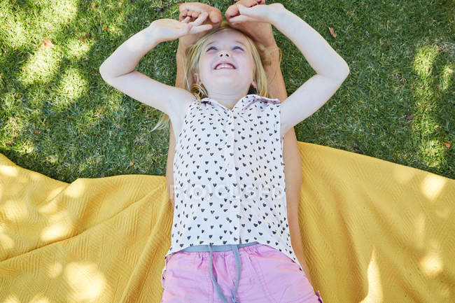 Chica feliz acostada en la manta y jugando con los pies de la madre - foto de stock