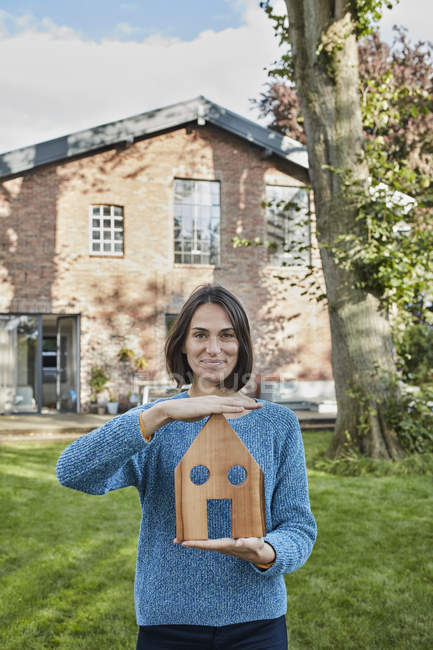 Ritratto di donna sorridente in giardino del suo modello di casa — Foto stock
