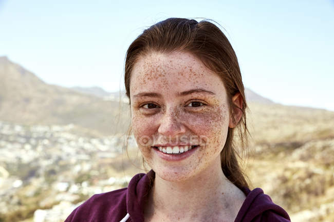 Portrait de jeune femme souriante avec des taches de rousseur à l'extérieur — Photo de stock