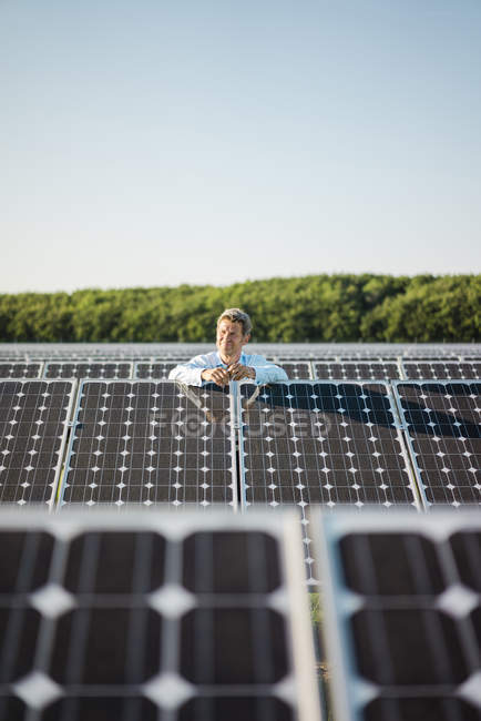 Зрілий чоловік стоїть на сонячній електростанції — стокове фото