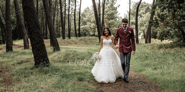 Noiva feliz e noivo andando na floresta — Fotografia de Stock