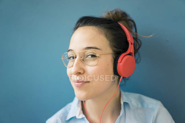 Portrait de femme souriante écoutant de la musique avec écouteurs — Photo de stock