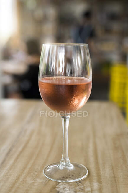 Стакан розового вина на деревянной сказке — стоковое фото