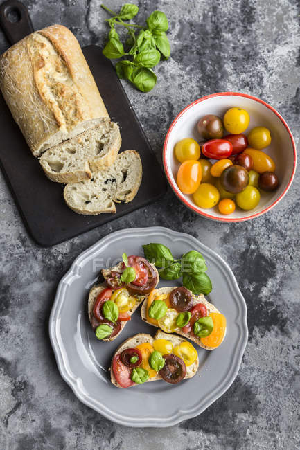 Bruschetta, ciabatta con pomodori multicolori e basilico — Foto stock