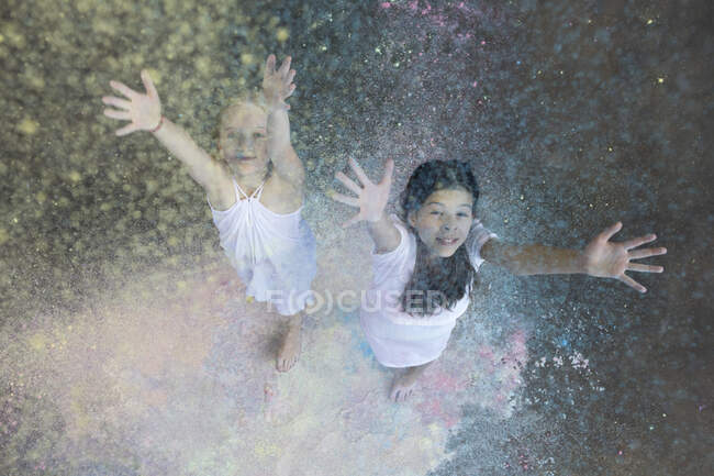 Портрет двох друзів, які кидають кольоровий порошок у повітря. — стокове фото