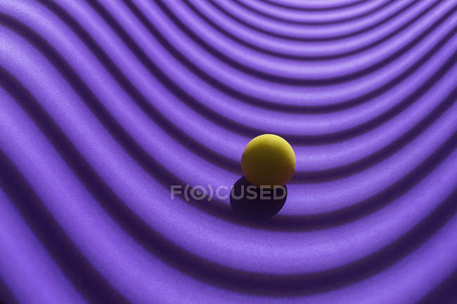 Esfera amarilla sobre un fondo geométrico púrpura, representación 3D - foto de stock