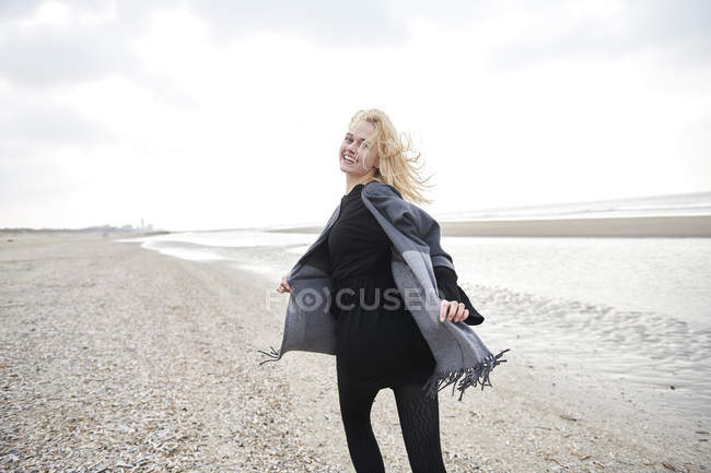 Pays-Bas, portrait d'une jeune femme blonde courant sur la plage — Photo de stock