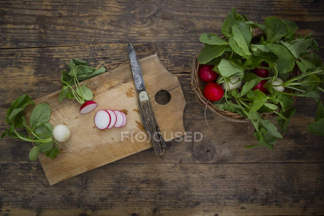 Red and white radish on chopping board — Stock Photo