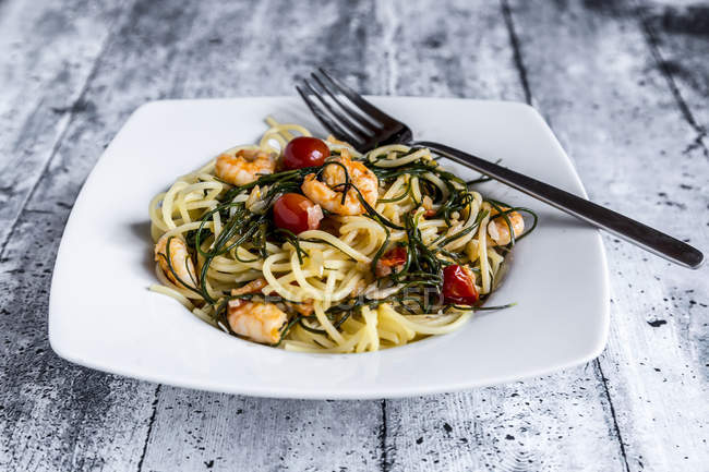 Spaghetti with prawns, tomatoes and opposite-leaved saltwort — Stock Photo