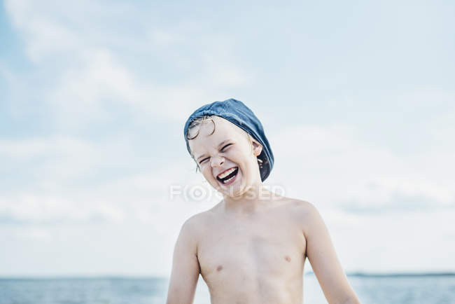 Portrait of happy boy wearing a cap at the sea — Stock Photo