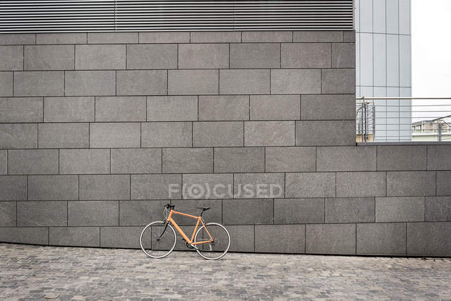 Bicicleta em um muro na cidade — Fotografia de Stock