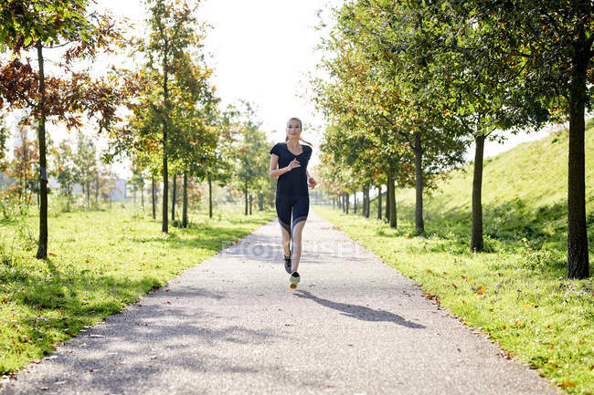 Mujer joven corriendo en un parque - foto de stock