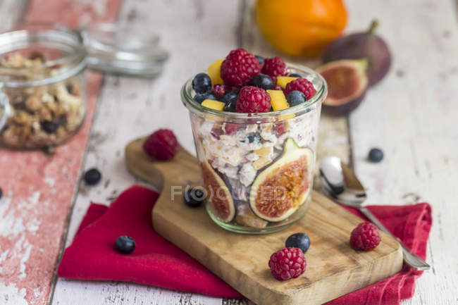 Verre de yaourt naturel avec granola et divers fruits — Photo de stock