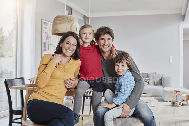 Retrato de família feliz com dois filhos em casa — Fotografia de Stock