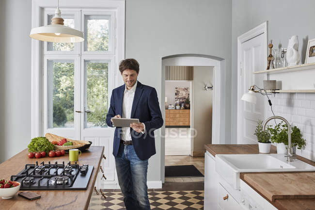 Uomo che utilizza tablet in cucina — Foto stock