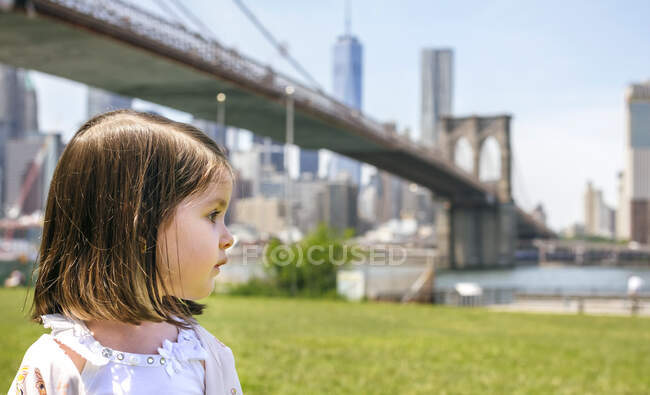 США, Нью - Йорк, Бруклін, Портрет маленької дівчинки в парку, оглядаючись убік з Бруклінським мостом. — стокове фото