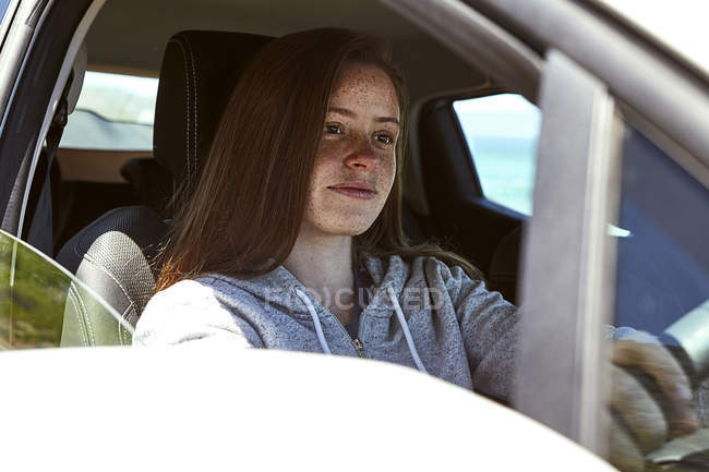 Портрет молодой женщины с веснушками за рулем автомобиля — стоковое фото