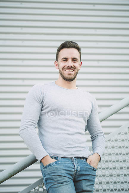 Retrato del hombre sonriente con las manos en los bolsillos - foto de stock