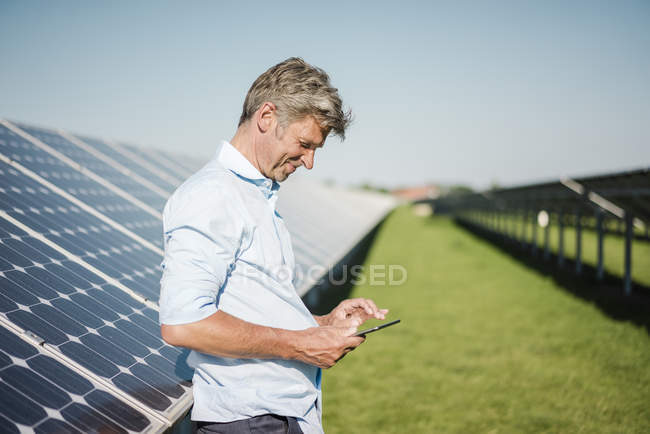 Бізнесмен використовує планшет у сонячному парку — стокове фото