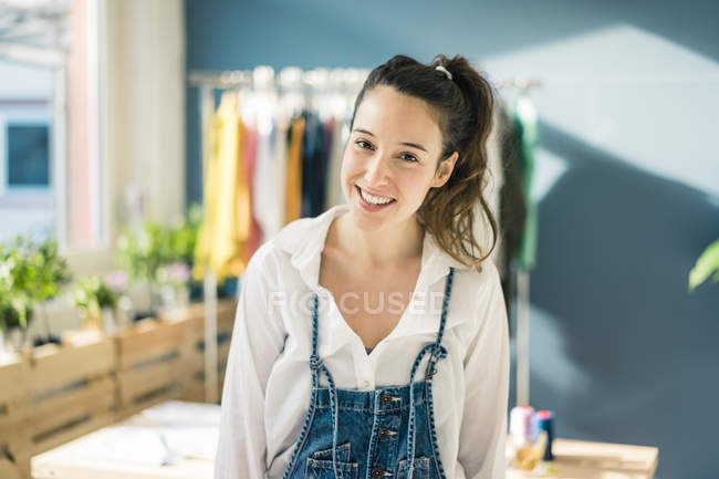 Portrait of smiling fashion designer in her studio — Stock Photo