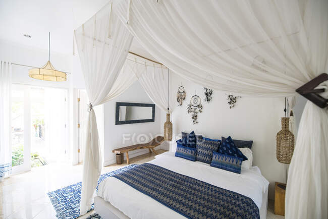 Cozy airy bedroom with blue pillows — Stock Photo