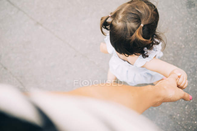Ragazza bambino che cammina tenendo la mano della madre — Foto stock