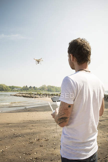 Man flying drone at a river — Stock Photo
