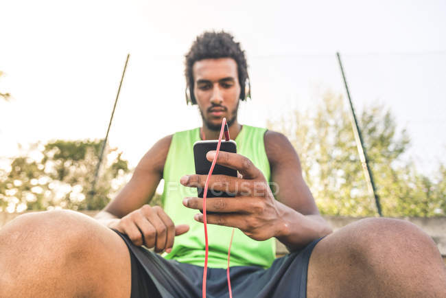 Giocatore di basket che ascolta musica, smartphone e cuffie — Foto stock