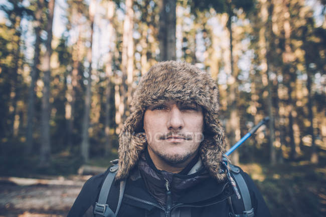 Schweden, Sodermanland, Porträt eines jungen Mannes mit Pelzmütze in abgelegener Landschaft — Stockfoto
