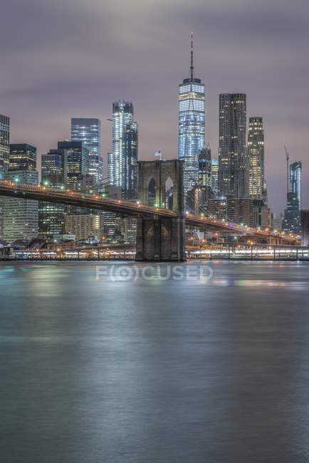 Estados Unidos, Nueva York, Manhattan, Brooklyn, paisaje urbano con Brooklyn Bridge por la noche - foto de stock