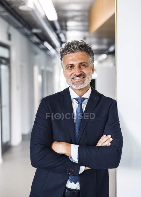 Retrato de un hombre de negocios maduro sonriente parado en el cargo - foto de stock