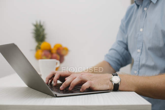 Businessman working on his laptop at home, partial view — Stock Photo
