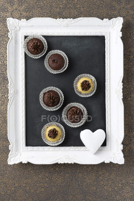 Small cupcakes with chocolate cream — Stock Photo
